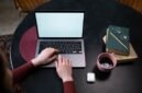 Seorang kreator konten sedang menyusun narasi pribadi di situs web miliknya sembari menikmati suasana tenang di sebuah kedai kopi. Kemudahan pengelolaan platform digital kini memberikan kemerdekaan penuh bagi individu untuk mempublikasikan karya tanpa batasan algoritma media sosial.